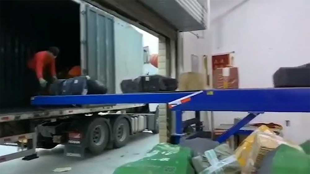 Курьерская компания занимается погрузкой картонных посылок в грузовики.