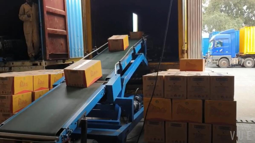 Портативный погрузочно-разгрузочный конвейер для грузовиков на заводе по производству продуктов питания и напитков
